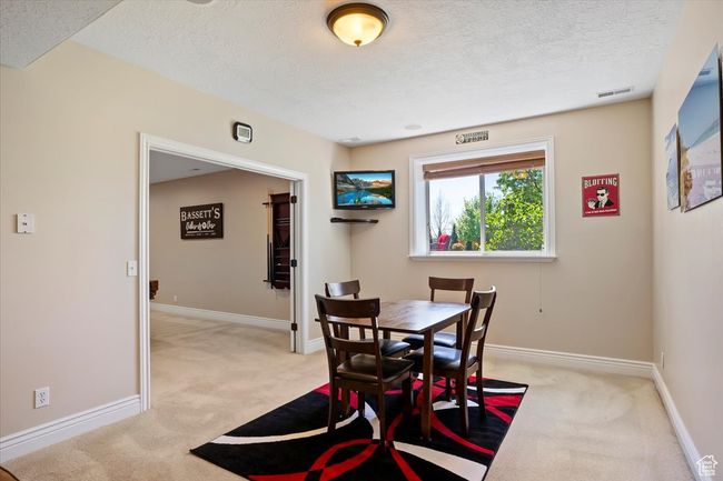 Dining area featuring baseboards, light carpet, a textured ceiling, and visible vents | Image 22