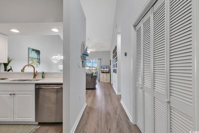 Kitchen featuring white cabinetry, dishwasher, sink, and pendant lighting | Image 2