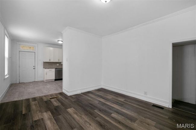 Spare room with dark wood finished floors and crown molding | Image 7