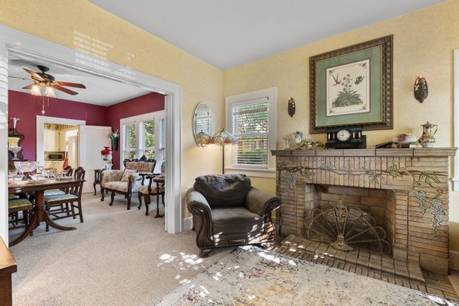 Living room featuring carpet flooring, ceiling fan, and a brick fireplace | Image 10