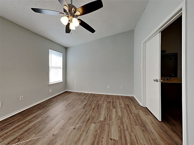 Unfurnished room featuring a textured ceiling, wood finished floors, and a ceiling fan | Image 8