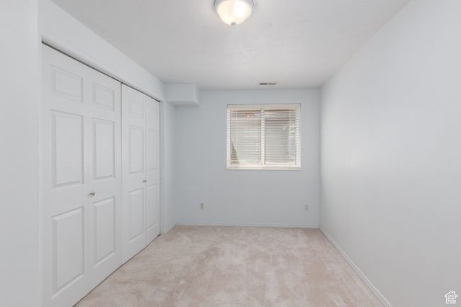 Unfurnished bedroom with carpet flooring, a closet, and baseboards | Image 17