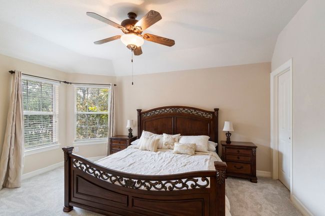 Bedroom featuring light carpet, baseboards, ceiling fan, and lofted ceiling | Image 30