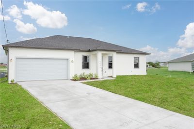 View of front of home with a garage, a front lawn, and central air condition unit | Image 1