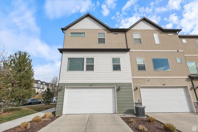Townhome / multi-family property with an attached garage, driveway, and central AC unit | Image 25