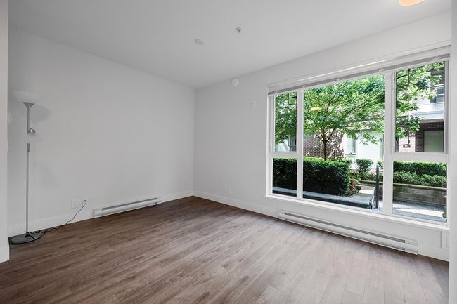 Unfurnished room with a baseboard heating unit and wood finished floors | Image 16
