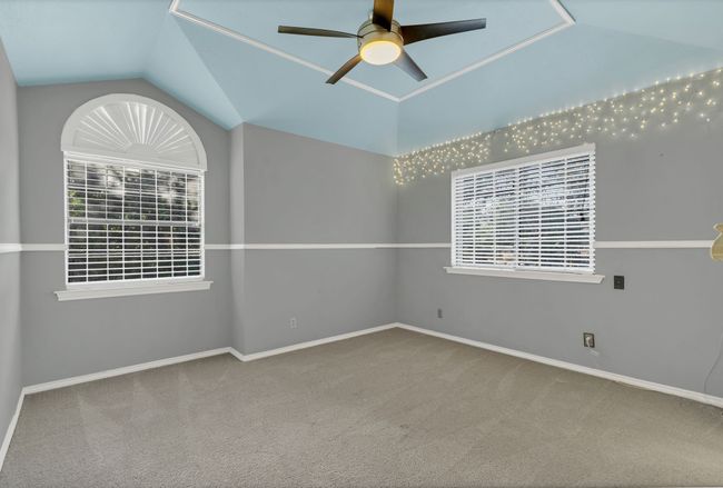 Carpeted spare room with a ceiling fan and vaulted ceiling | Image 27