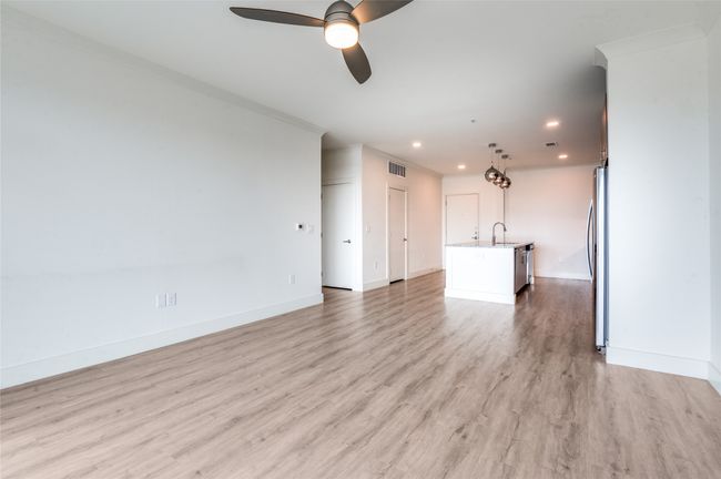 Unfurnished living room with a ceiling fan, recessed lighting, light wood-type flooring, and crown molding | Image 12