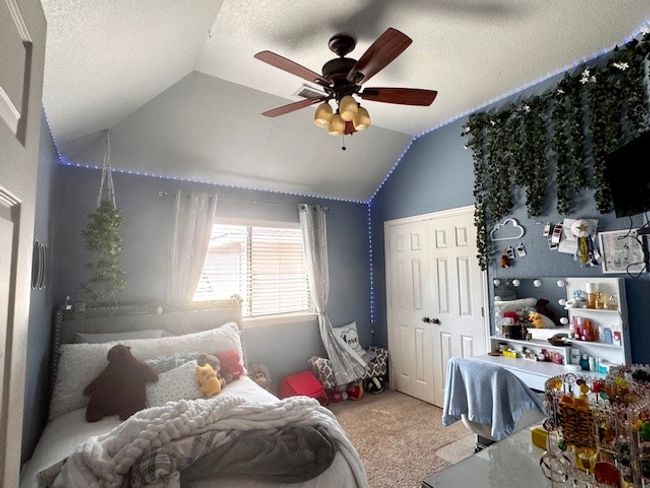 Bedroom with ceiling fan, a textured ceiling, a closet, vaulted ceiling, and carpet flooring | Image 17