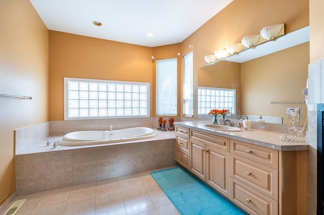Full bath featuring tile patterned flooring, plenty of natural light, visible vents, and a bath | Image 26