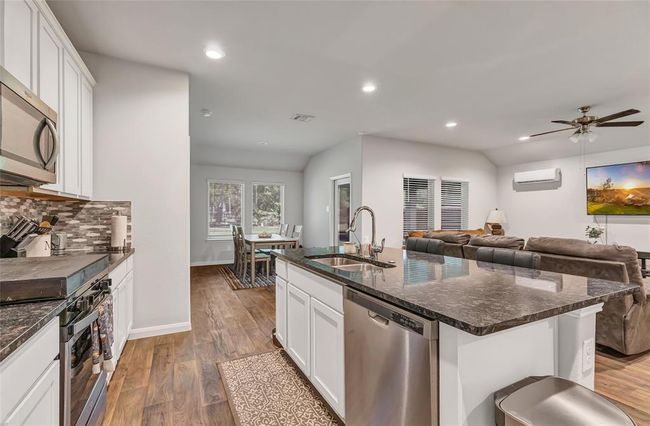 Kitchen has open concept to living and dining area with view of backyard | Image 20