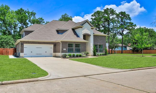 Situated on a well-maintained corner lot, the home includes a double driveway and a direct sidewalk path to the backyard. | Image 4