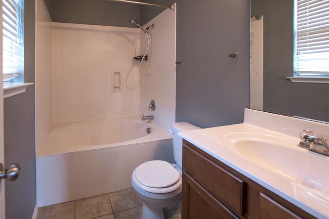 Bathroom featuring toilet, vanity, shower combination, and tile patterned flooring | Image 28