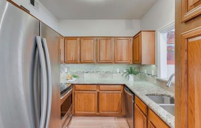 Kitchen featuring appliances with stainless steel finishes, backsplash, and light stone countertops | Image 5