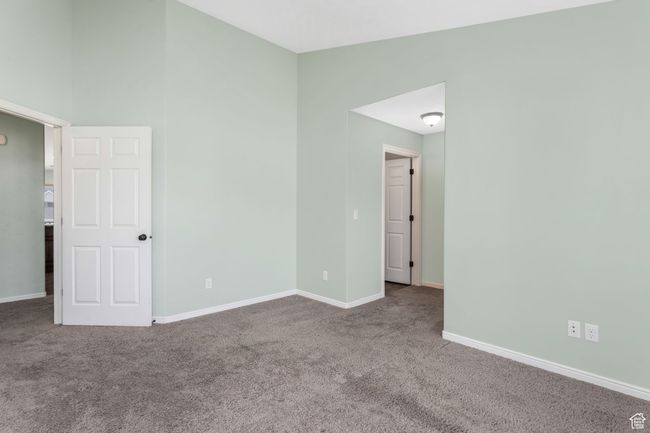 Carpeted empty room featuring baseboards and vaulted ceiling | Image 12