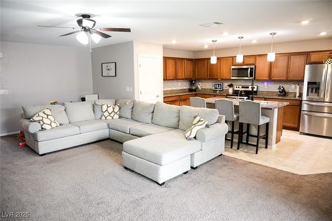 Living area with recessed lighting, visible vents, a ceiling fan, light carpet, and light tile patterned flooring | Image 13