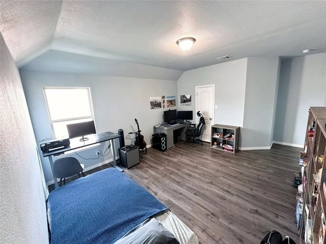 Upstairs bedroom featuring a textured ceiling, vaulted ceiling, and wood finished floors | Image 21