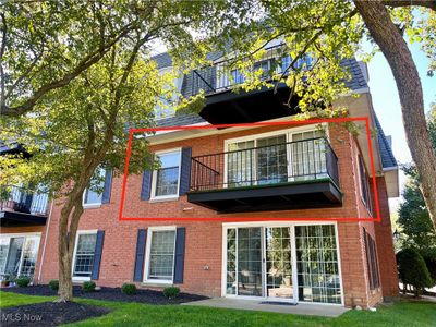 Rear view of house with a balcony and a lawn | Image 1