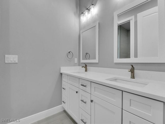 Bathroom with double vanity and baseboards | Image 26
