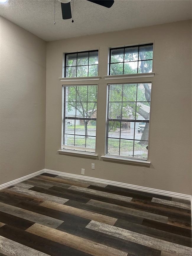Spare room featuring ceiling fan, dark wood finished floors, and a textured ceiling | Image 17