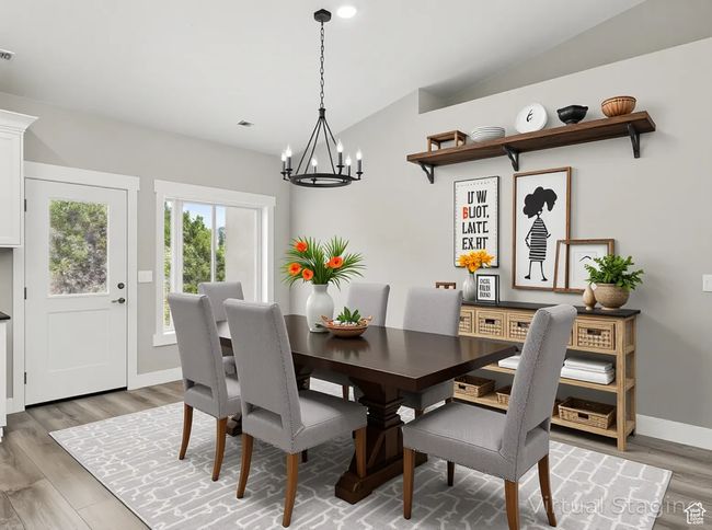 Dining area with vaulted ceiling, a chandelier, light wood finished floors, and baseboards | Image 15