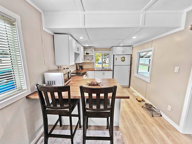 Dining room with light wood-type flooring, baseboards, and recessed lighting | Image 6