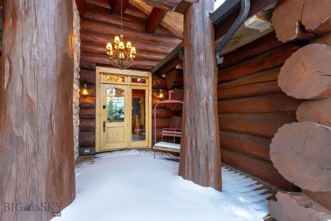 Front door entryway with ski chair lift and massive logs. | Image 67