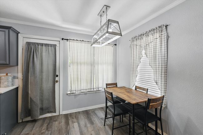 Dining room featuring dark wood finished floors, crown molding, and plenty of natural light | Image 9