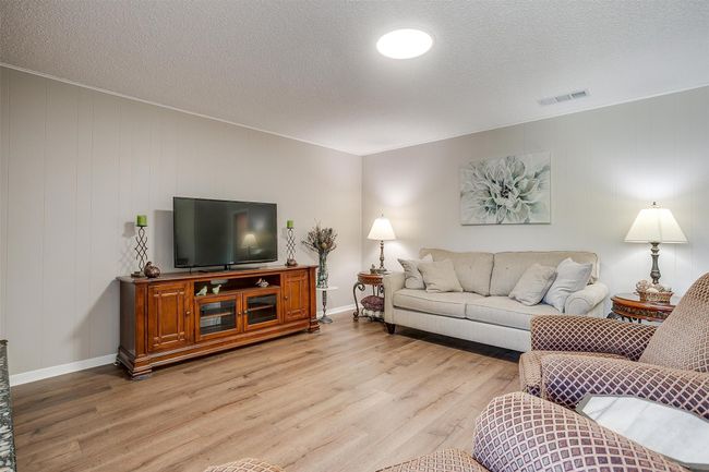 Living room with light wood-type flooring and a textured ceiling | Image 13