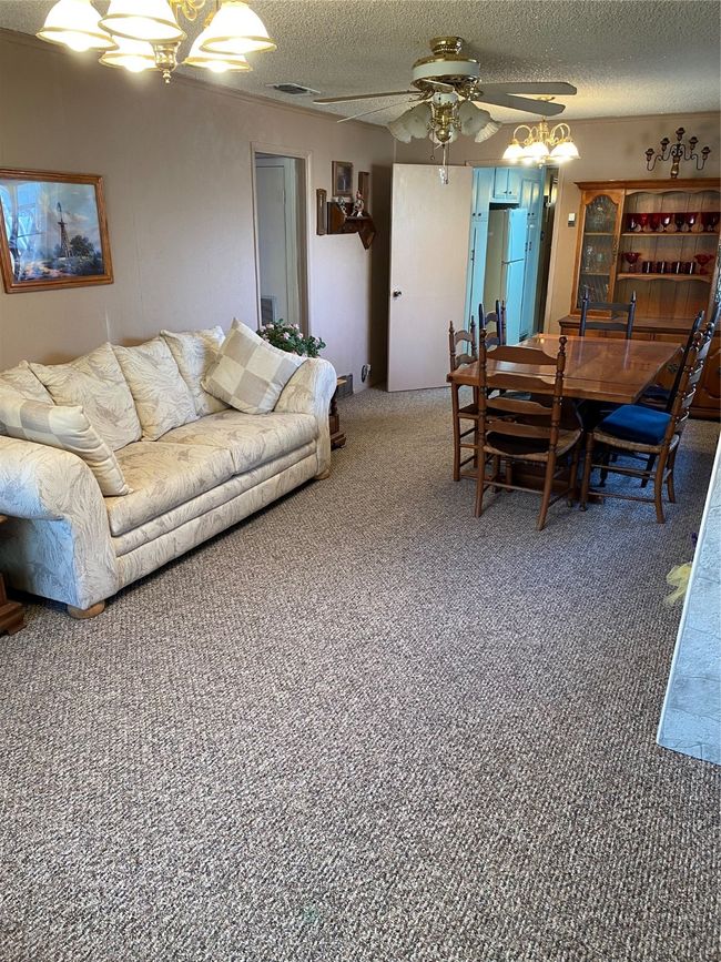 Carpeted dining room with ceiling fan and a textured ceiling | Image 15