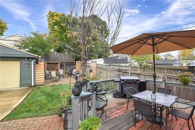 Wooden deck featuring a garage and area for grilling | Image 2