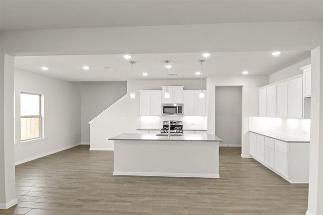Kitchen featuring stainless steel appliances, light wood-style flooring, baseboards, and backsplash | Image 15