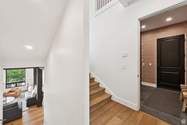 Stairway featuring wood finished floors, a towering ceiling, and recessed lighting | Image 43