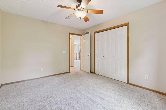 This room is accentuated with raised panel doors and a ceiling fan | Image 16