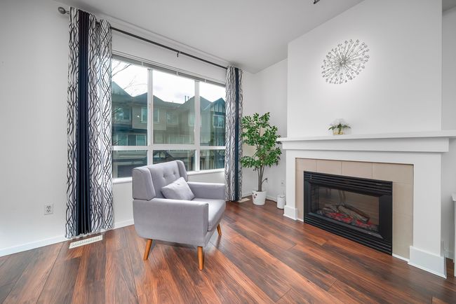 Sitting room with a fireplace, baseboards, and wood finished floors | Image 18
