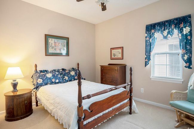 Bedroom with light carpet, baseboards, and ceiling fan | Image 13