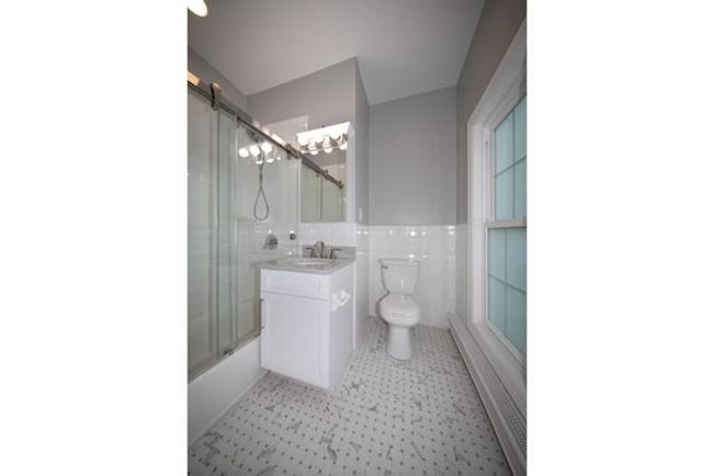 Full bathroom with vanity, tile walls, and combined bath / shower with glass door | Image 5