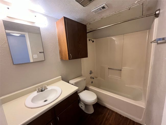 This bathroom has a shower/tub combination. Notice the extra cabinet over the toilet. | Image 7