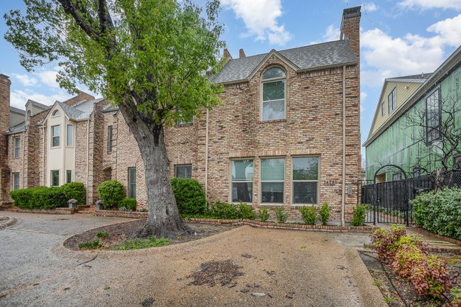 View of front of house with roof with shingles, a chimney, fence, and brick siding | Image 23