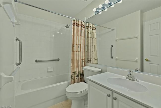 Full bathroom with tile patterned floors, vanity, shower / tub combo, and toilet | Image 12