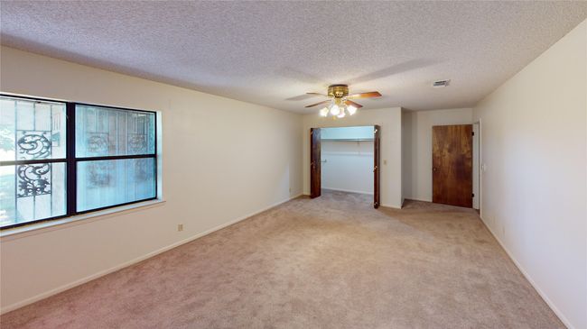 Unfurnished room with ceiling fan, light carpet, a textured ceiling, and baseboards | Image 10