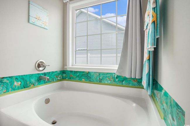 Bathroom featuring healthy amount of natural light and a garden tub | Image 15