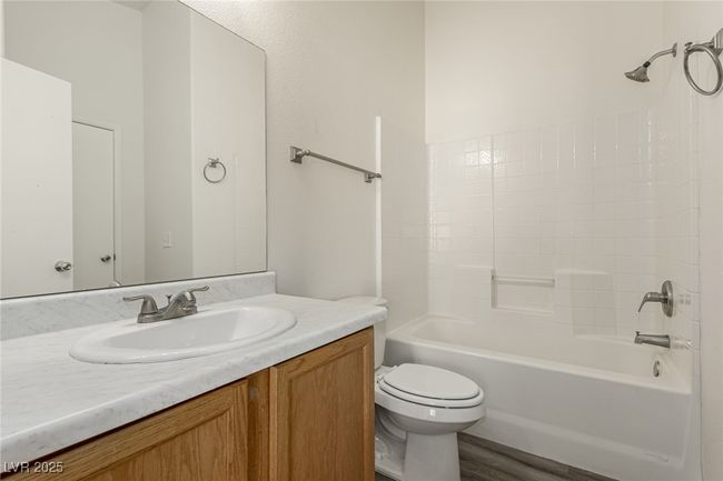 Bathroom featuring toilet, vanity, shower combination, and wood finished floors | Image 19
