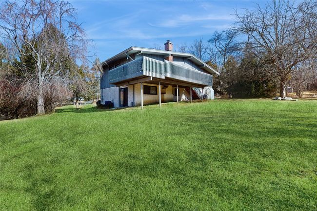 Back of house with a lawn, a chimney, and a deck | Image 29
