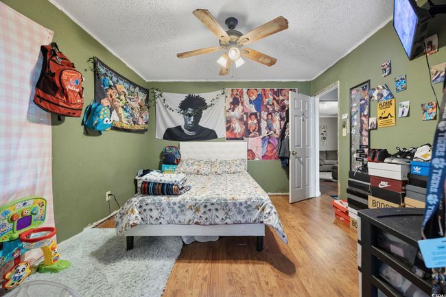 Bedroom with a textured ceiling, wood finished floors, and a ceiling fan | Image 8