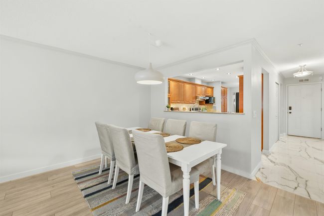 Dining area with light wood finished floors, recessed lighting, visible vents, ornamental molding, and baseboards | Image 13