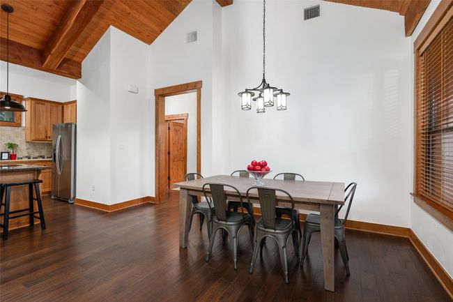 This dining area combines simplicity with elegance, featuring an updated light fixture which adds a touch of style, while large windows bring in natural light. | Image 10