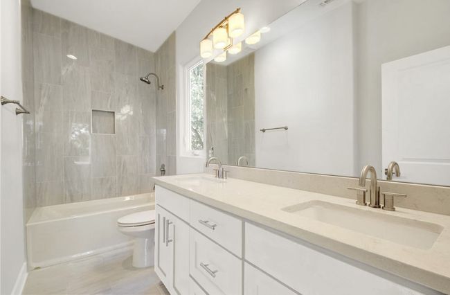 Full bath featuring double vanity, toilet, a sink, and shower / bathing tub combination | Image 19