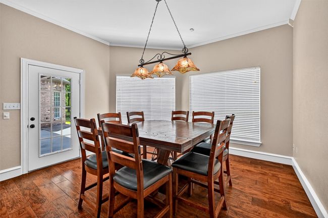 Dining area with crown molding, baseboards, and dark wood-style flooring | Image 18