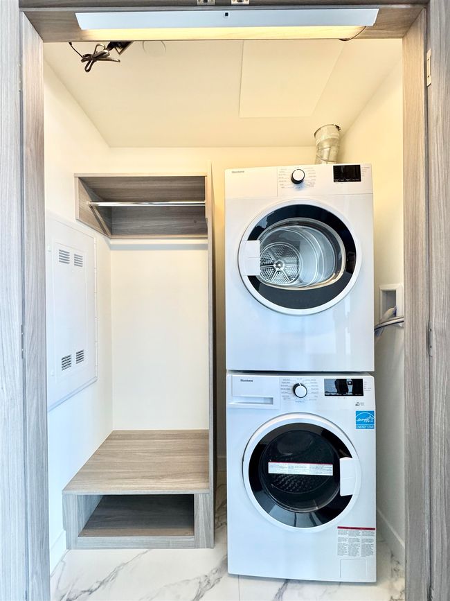 Laundry room with marble finish floor, stacked washer and dryer, and laundry area | Image 8